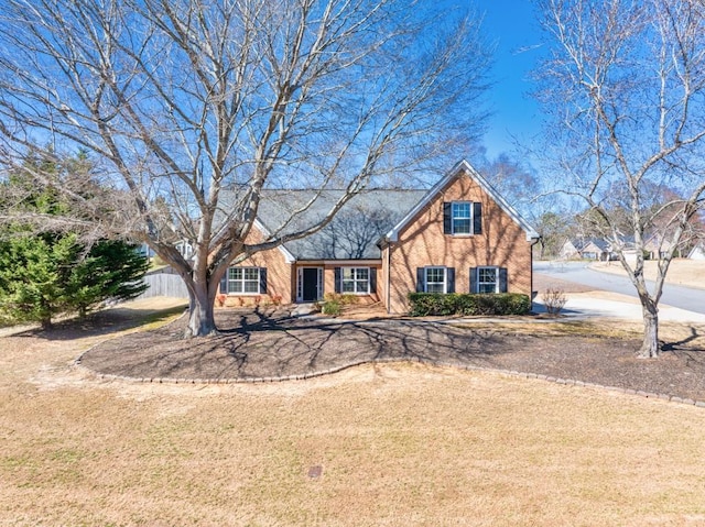 view of front of house with brick siding and fence