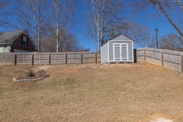 view of yard with an outbuilding, a shed, and a fenced backyard