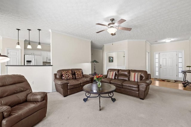 living room with ornamental molding, ceiling fan, and a textured ceiling