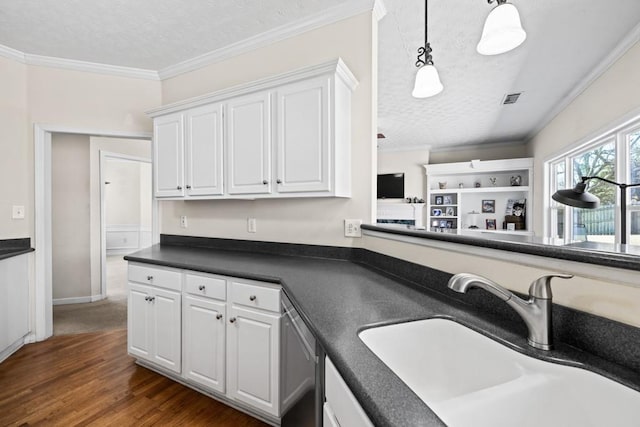 kitchen with visible vents, dishwasher, dark countertops, ornamental molding, and a sink