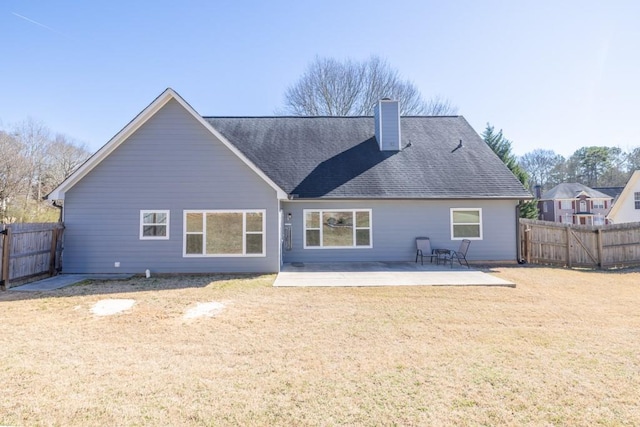 rear view of property with fence private yard, a patio area, a chimney, and a lawn