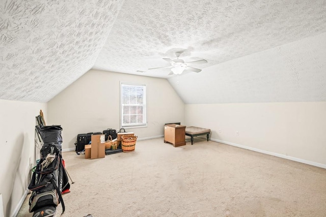 bonus room featuring lofted ceiling, a textured ceiling, carpet floors, a ceiling fan, and baseboards