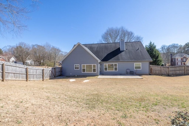 back of property featuring a patio area, a fenced backyard, a lawn, and a chimney