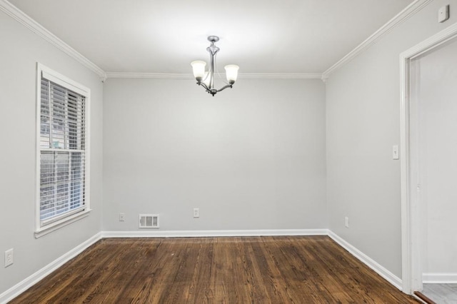 empty room featuring crown molding, dark wood-type flooring, and a notable chandelier