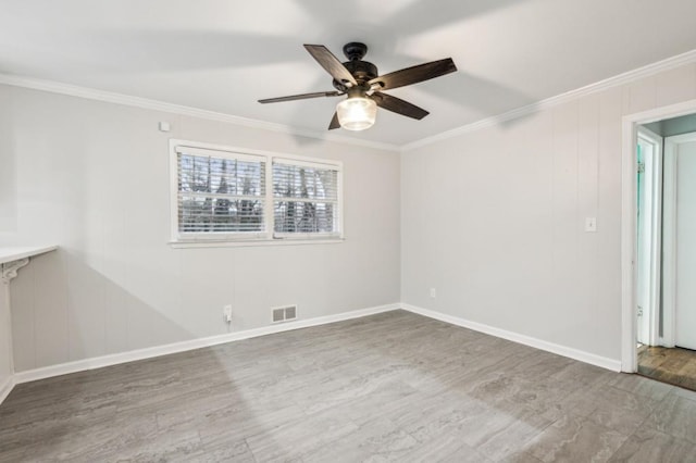 spare room featuring ceiling fan, ornamental molding, and wood-type flooring