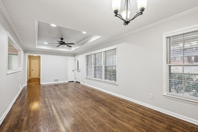 unfurnished room featuring ornamental molding, a tray ceiling, dark hardwood / wood-style flooring, and ceiling fan with notable chandelier