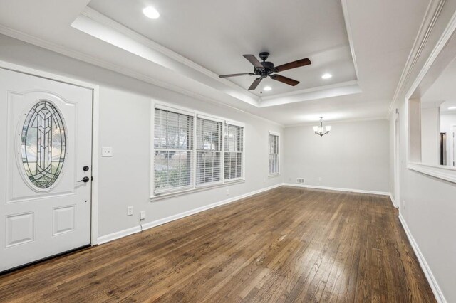 entryway featuring ornamental molding, dark hardwood / wood-style floors, ceiling fan with notable chandelier, and a tray ceiling