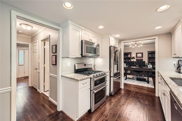 2917 Townley Cir, Atlanta, GA 30340 - kitchen with stainless steel appliances, crown molding, dark wood-style floors, white cabinets, and light stone countertops