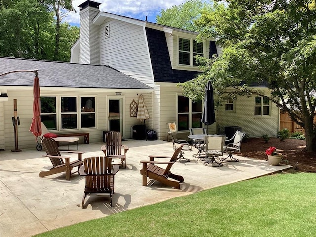 2917 Townley Cir, Atlanta, GA 30340 - back of house with roof with shingles, a patio area, a chimney, a gambrel roof, and a yard
