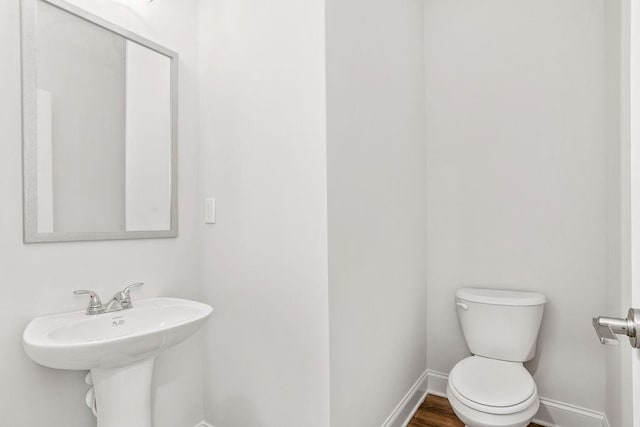 bathroom featuring hardwood / wood-style flooring, sink, and toilet