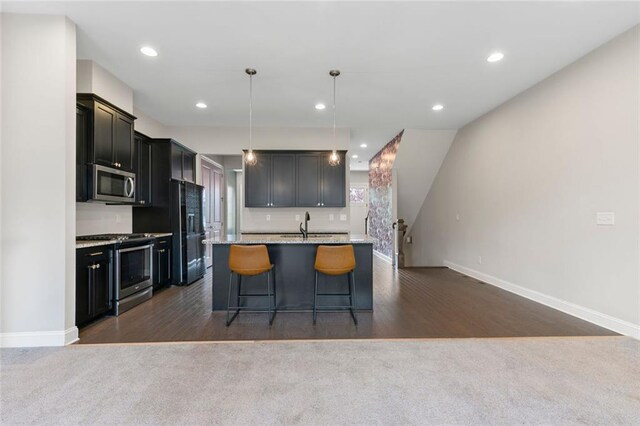 1954 Summit Trace Cir NW, Atlanta, GA 30318 - kitchen featuring stainless steel appliances, dark carpet, pendant lighting, an island with sink, and recessed lighting