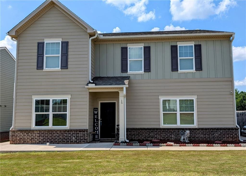 15 Regal Ln, Covington, GA 30016 - view of front of house featuring brick siding, board and batten siding, and a front lawn