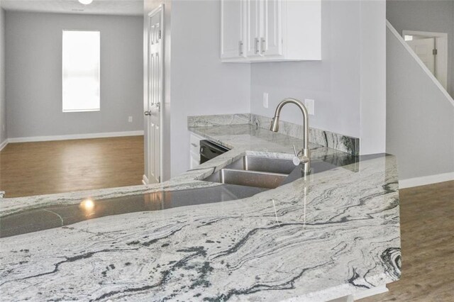 kitchen featuring sink, light hardwood / wood-style flooring, kitchen peninsula, white cabinets, and black appliances