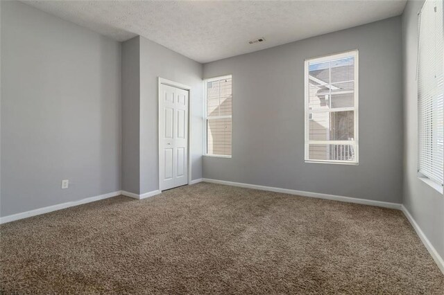 unfurnished bedroom featuring carpet flooring, a closet, and a textured ceiling