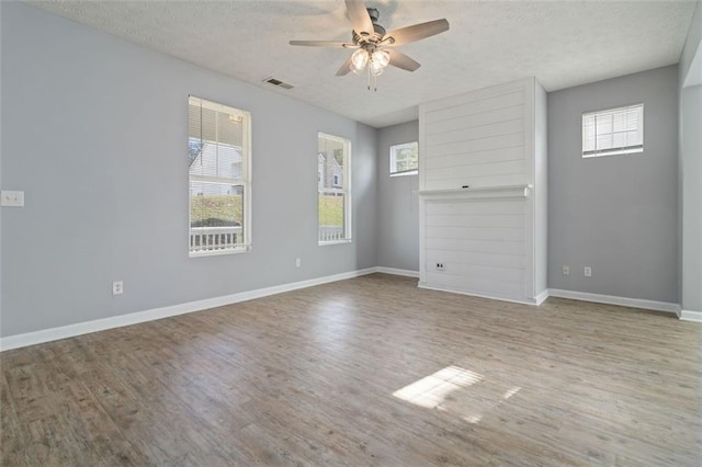 empty room featuring ceiling fan, wood-type flooring, and a textured ceiling