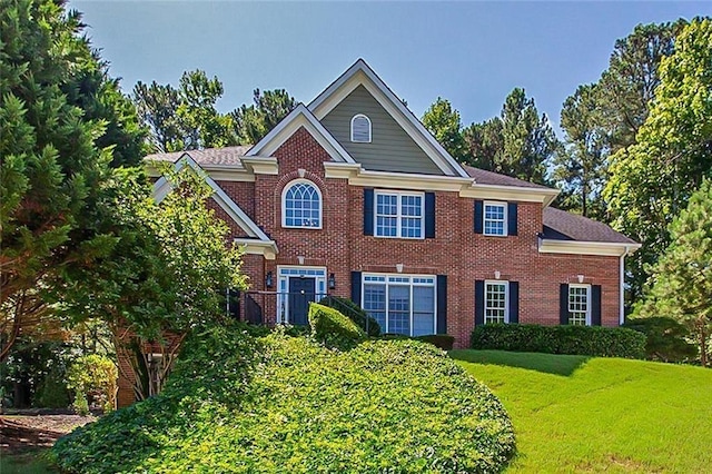 colonial home with a front lawn and brick siding