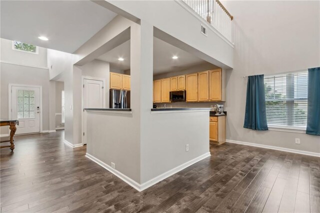7927 Keepsake Ln, Flowery Branch, GA 30542 - kitchen with stainless steel fridge with ice dispenser, dark wood-style floors, light brown cabinets, recessed lighting, and dark countertops