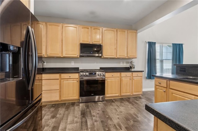 7927 Keepsake Ln, Flowery Branch, GA 30542 - kitchen with stainless steel appliances, light brown cabinetry, dark countertops, and dark wood finished floors