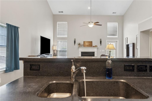7927 Keepsake Ln, Flowery Branch, GA 30542 - kitchen with ceiling fan, open floor plan, a fireplace, and dark countertops