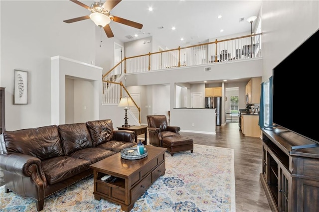 7927 Keepsake Ln, Flowery Branch, GA 30542 - living room featuring a high ceiling, a ceiling fan, wood finished floors, stairway, and recessed lighting