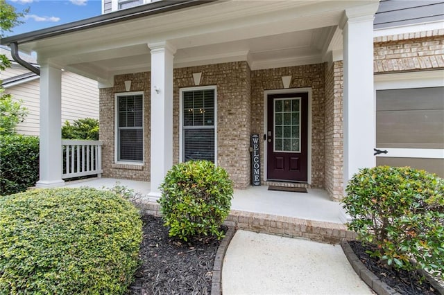 7927 Keepsake Ln, Flowery Branch, GA 30542 - view of exterior entry with a porch and brick siding