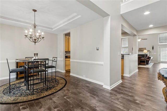 7927 Keepsake Ln, Flowery Branch, GA 30542 - dining room featuring dark wood-style flooring, a raised ceiling, ceiling fan, a chandelier, and recessed lighting