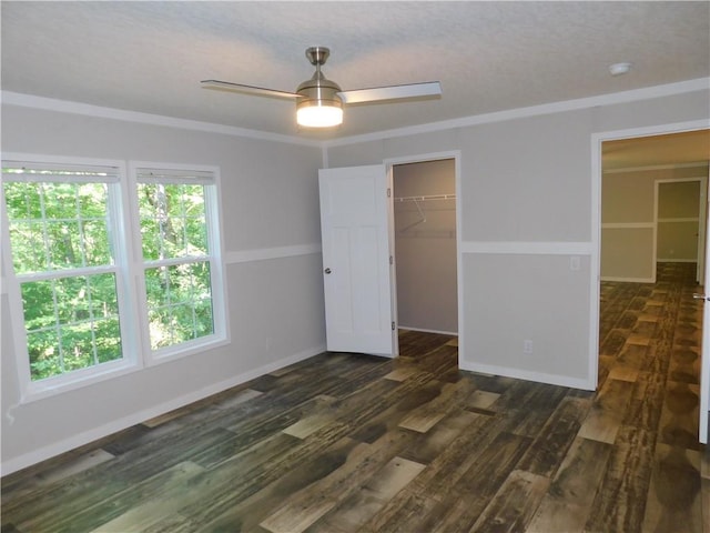 129 Lost Pl, Dahlonega, GA 30533 - unfurnished bedroom with dark wood-style flooring, a spacious closet, a closet, ornamental molding, and ceiling fan