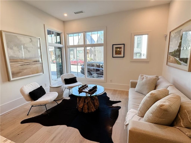 living area featuring light wood-type flooring, visible vents, baseboards, and recessed lighting