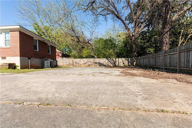 view of yard with fence and central AC unit