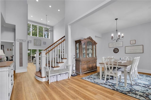 1033 Lanier Ave, Gainesville, GA 30501 - dining space with a notable chandelier, recessed lighting, stairway, light wood-style flooring, and a high ceiling
