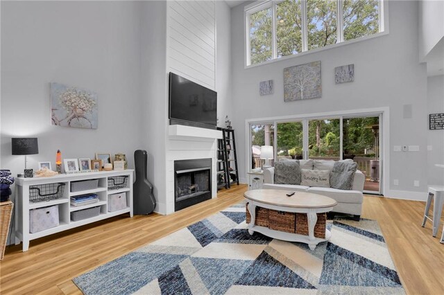 1033 Lanier Ave, Gainesville, GA 30501 - living room featuring plenty of natural light, a fireplace, a high ceiling, and wood finished floors