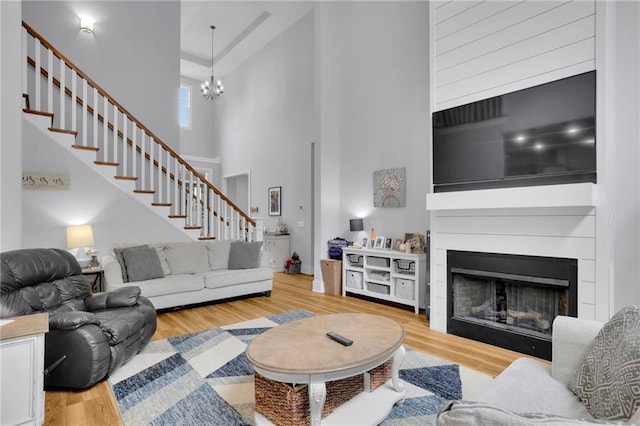 1033 Lanier Ave, Gainesville, GA 30501 - living area with stairs, a high ceiling, a fireplace, and wood finished floors