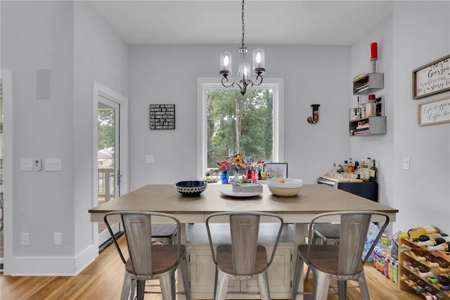 1033 Lanier Ave, Gainesville, GA 30501 - dining space with baseboards, light wood-type flooring, and an inviting chandelier