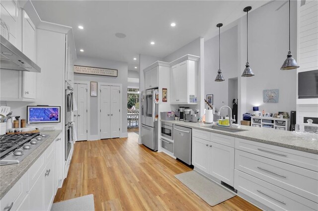 1033 Lanier Ave, Gainesville, GA 30501 - kitchen with stainless steel appliances, white cabinets, a sink, and wall chimney range hood