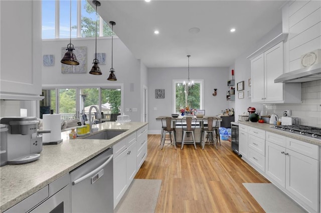 1033 Lanier Ave, Gainesville, GA 30501 - kitchen with decorative backsplash, light wood-style flooring, wine cooler, stainless steel appliances, and a sink
