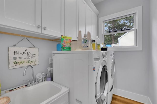 1033 Lanier Ave, Gainesville, GA 30501 - laundry room featuring a sink, light wood-style floors, baseboards, cabinet space, and washing machine and clothes dryer