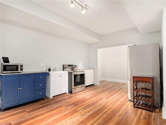 1033 Lanier Ave, Gainesville, GA 30501 - kitchen with stainless steel appliances, light countertops, light wood-style flooring, blue cabinets, and baseboards