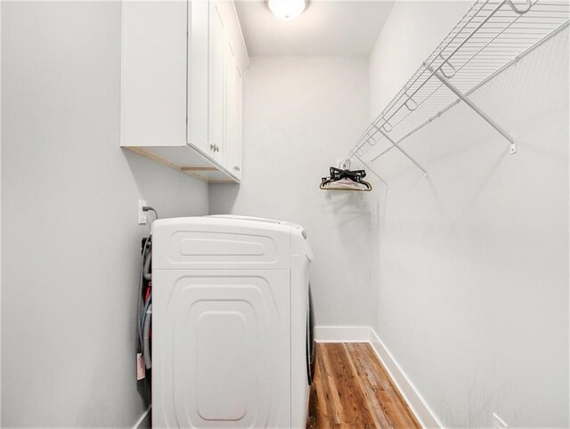 1033 Lanier Ave, Gainesville, GA 30501 - washroom with light wood-type flooring, cabinet space, baseboards, and washer and dryer