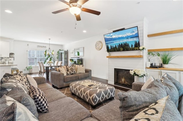 living room with a glass covered fireplace, ceiling fan, baseboards, and recessed lighting