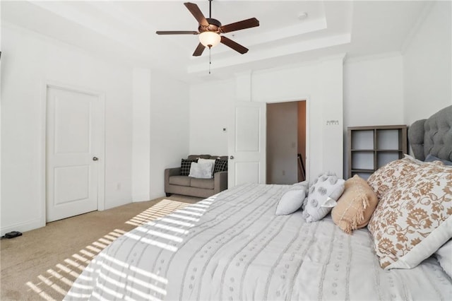 bedroom with baseboards, a ceiling fan, a raised ceiling, and carpet flooring