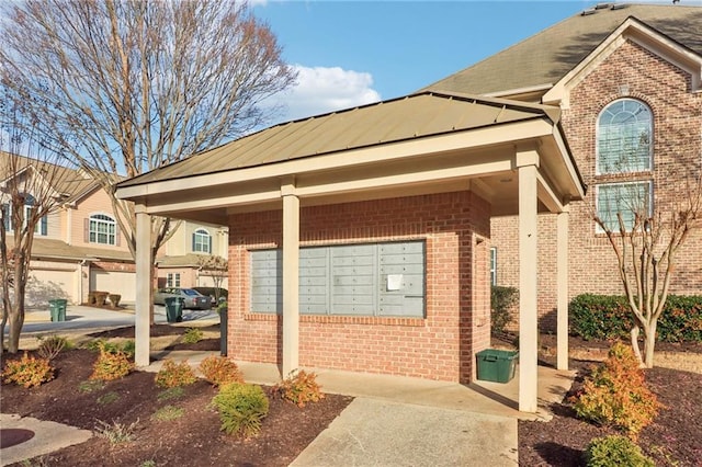 exterior space with a standing seam roof, metal roof, and brick siding