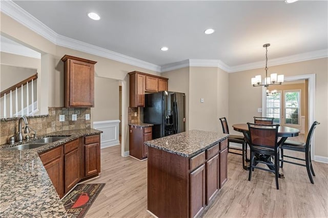 971 Reap Ln, Lawrenceville, GA 30043 - kitchen featuring black fridge with ice dispenser, light wood-style floors, dark stone countertops, backsplash, and a center island