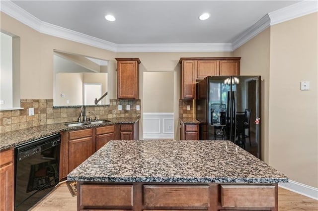 971 Reap Ln, Lawrenceville, GA 30043 - kitchen with black appliances, dark stone countertops, a kitchen island, light wood-style flooring, and ornamental molding