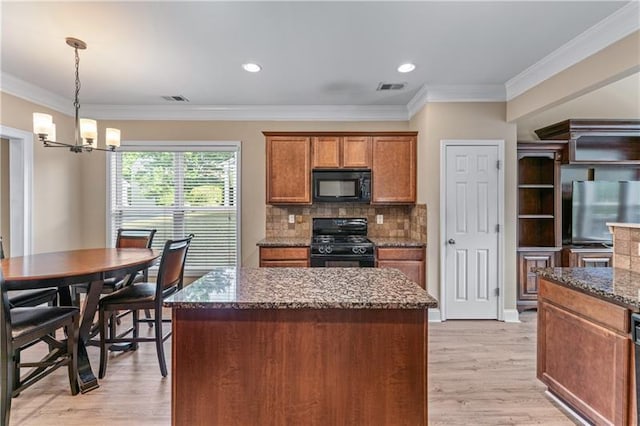 971 Reap Ln, Lawrenceville, GA 30043 - kitchen with black appliances, a chandelier, brown cabinetry, dark stone countertops, and a kitchen island