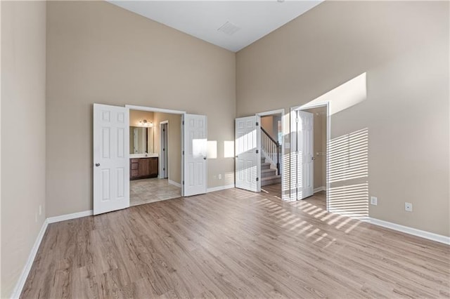 971 Reap Ln, Lawrenceville, GA 30043 - spare room featuring a towering ceiling, light wood-type flooring, and stairs