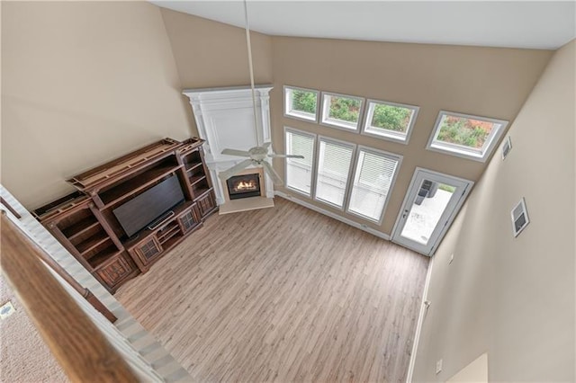 971 Reap Ln, Lawrenceville, GA 30043 - unfurnished living room featuring high vaulted ceiling, wood finished floors, and a lit fireplace