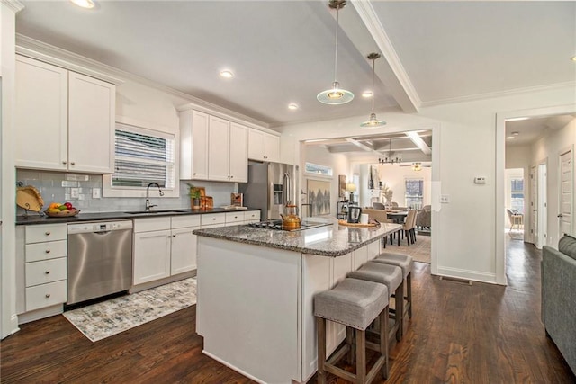 kitchen featuring a sink, stainless steel appliances, dark wood-style floors, and a breakfast bar area