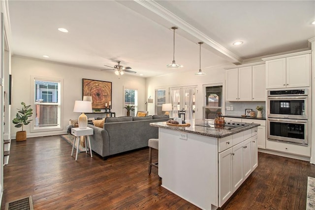 kitchen featuring dark wood-style floors, visible vents, a kitchen island, double oven, and black electric cooktop