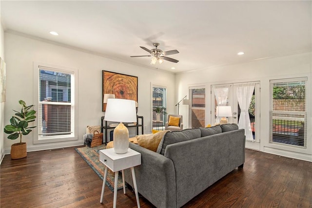 living room with dark wood-type flooring, a ceiling fan, and ornamental molding