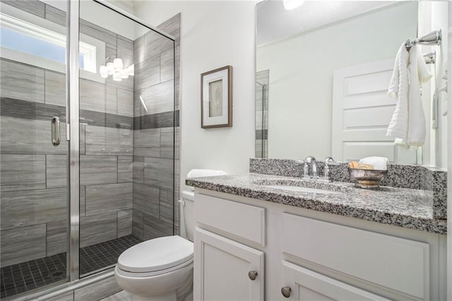 bathroom featuring vanity, toilet, and a stall shower